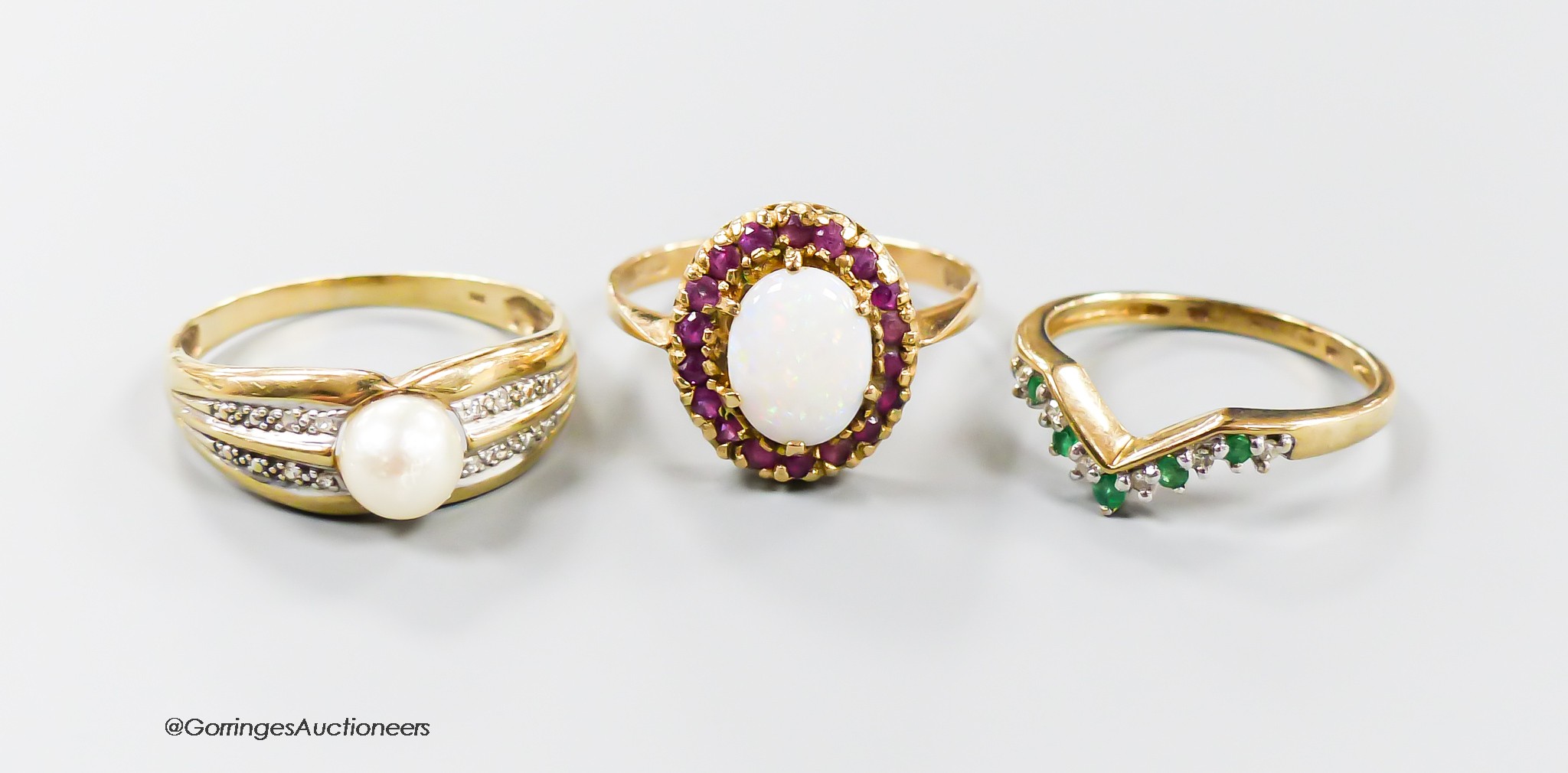 Two 9ct gold and gem set rings, ruby and white opal cluster and emerald and diamond herringbone and a 375 and cultured pearl ring, gross weight 6.8 grams.